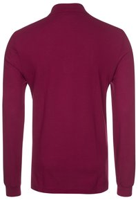 Camisa polo de manga larga burdeos con cuello acanalado y una tela texturizada. La parte trasera es lisa, sin logotipos ni diseños visibles.