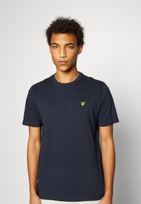 T-shirt blu navy a maniche corte realizzato in tessuto morbido, con scollatura rotonda e un piccolo logo ricamato sul petto sinistro.