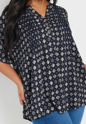 Marineblouse met een diamantenpatroon in crème en blauw, voorzien van een kraag, drie knopen en een A-lijn silhouet. Zachte, gestructureerde stof.