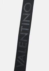 Svart tekstilrem med vevet tekstur, preget "VALENTINO"-logo i grått, med flatt design og rektangulær form.