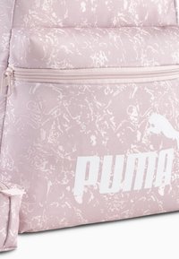 Zaino rosa a motivo con design testurizzato, logo bianco prominente e tasca anteriore con zip. Materiale durevole con spallacci regolabili.