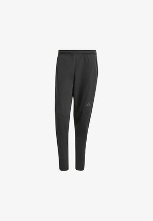 Black athletic pants with a tapered fit, made from a soft material. Features side pockets and a logo accent on the left thigh.