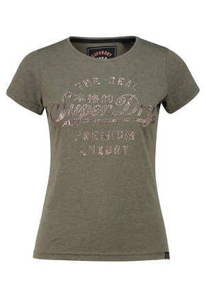 Zielony t-shirt z krótkim rękawem i okrągłym dekoltem z wyblakłym beżowym napisem ""The Real Super Dry Premium Luxury"" na przodzie.