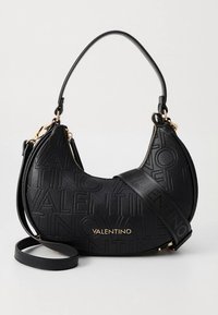 Juodos odos rankinė su iškilų „Valentino“ logotipą, lenktos formos, trumpa viršutinė rankena ir ilgas petnešos dirželis su auksinės spalvos detalėmis.