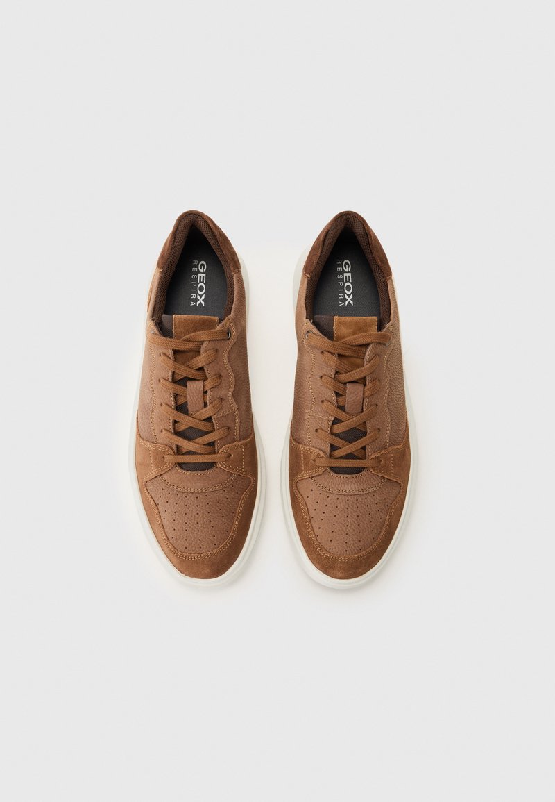 Braune Leder-Sneaker mit durchbrochenen Akzenten und Schnürsenkeln. Verfügt über eine weiße Laufsohle und eine schwarze Einlegesohle mit "Geox Respira"-Markierung.