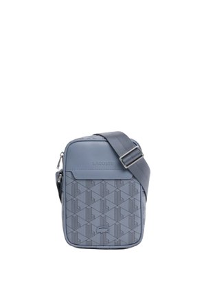 Pequeño bolso azul Lacoste para llevar al hombro con correa ajustable, patrón geométrico, logo en relieve y bolsillo delantero con cremallera.
