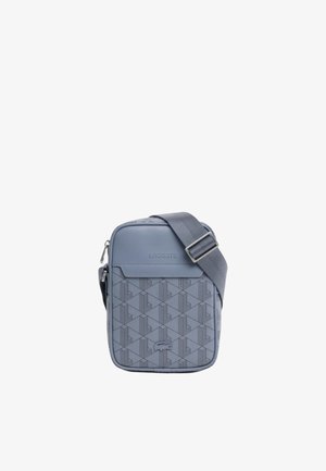 Pequeño bolso azul Lacoste para llevar al hombro con correa ajustable, patrón geométrico, logo en relieve y bolsillo delantero con cremallera.