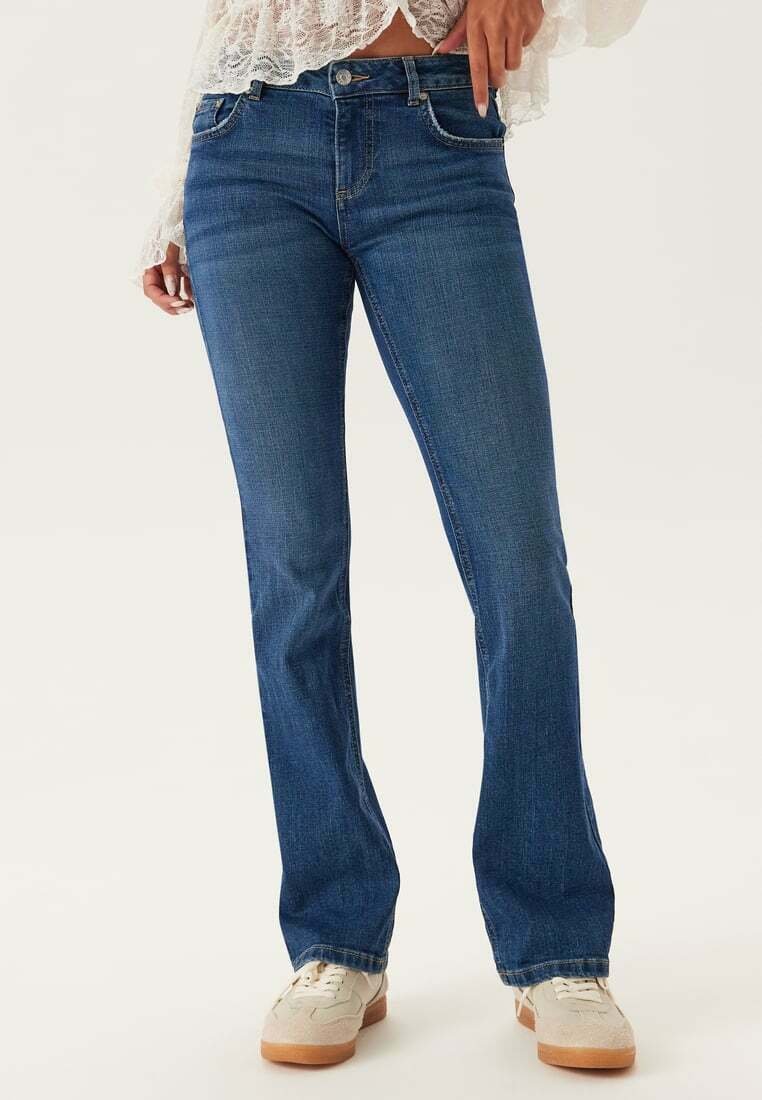 Blå utsvängda jeans med medelhög midja, med en klassisk femfickdesign, denimtextur och kontrasterande sömmar längs kanterna.