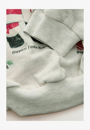 Hanorac gri deschis cu manșete cu nervuri, având un design festiv imprimat. Textură moale, ușoare pliuri vizibile și text care spune "Cele mai fericite momente festive."