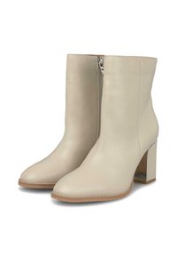 Bottes de cheville en cuir beige avec un bout pointu, une fermeture éclair sur le côté et un talon bloc argenté brillant. Texture lisse.