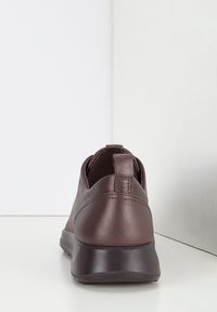 Sneaker in pelle marrone con profilo basso, forma rotonda e linguetta sul tallone. Finitura testurizzata con suola in gomma a contrasto.