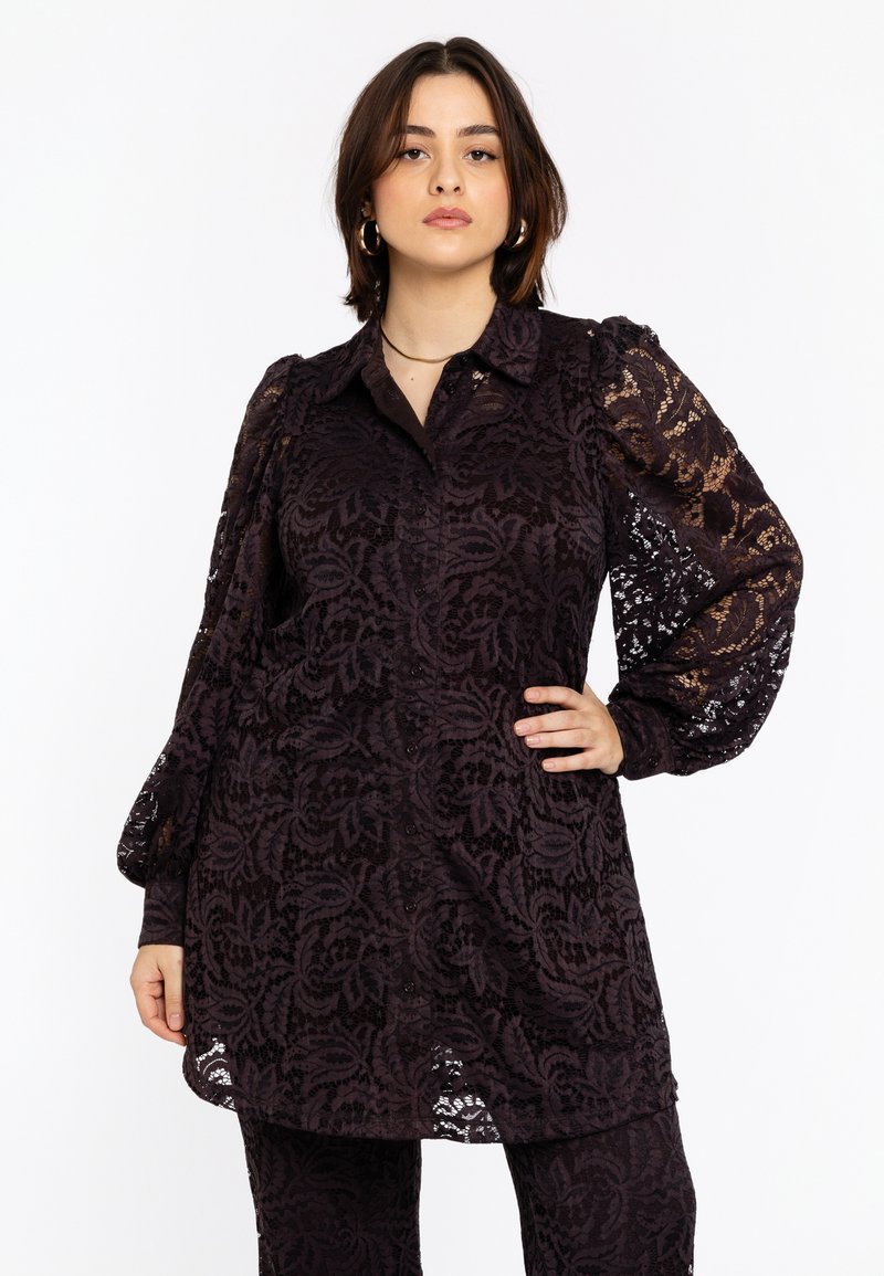 Zwarte kanten blouse met lange pofmouwen, knoopsluiting aan de voorkant, bloemenpatroon en licht uitlopende zoom. Geaccentueerd met een doorzichtige textuur.