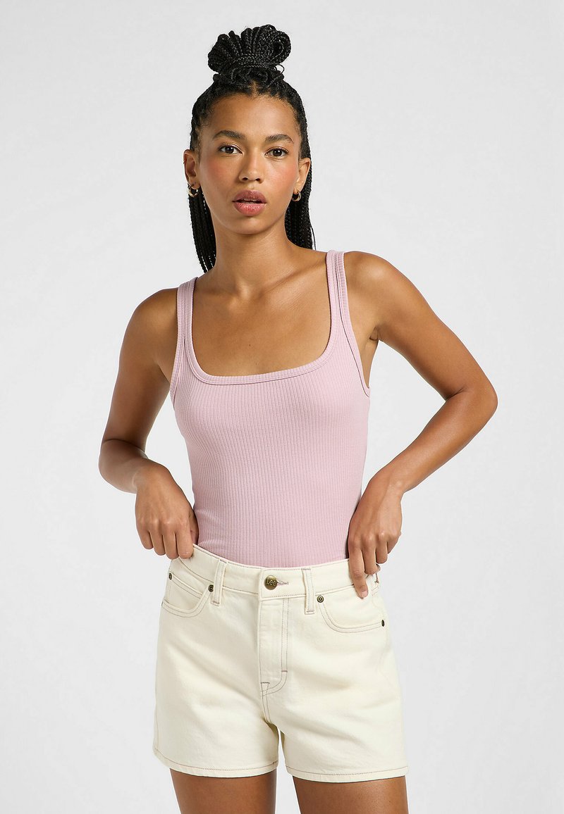 Lys pink ribbet tanktop med brede stropper parret med lys beige shorts med frontlommer og en knaplukning.