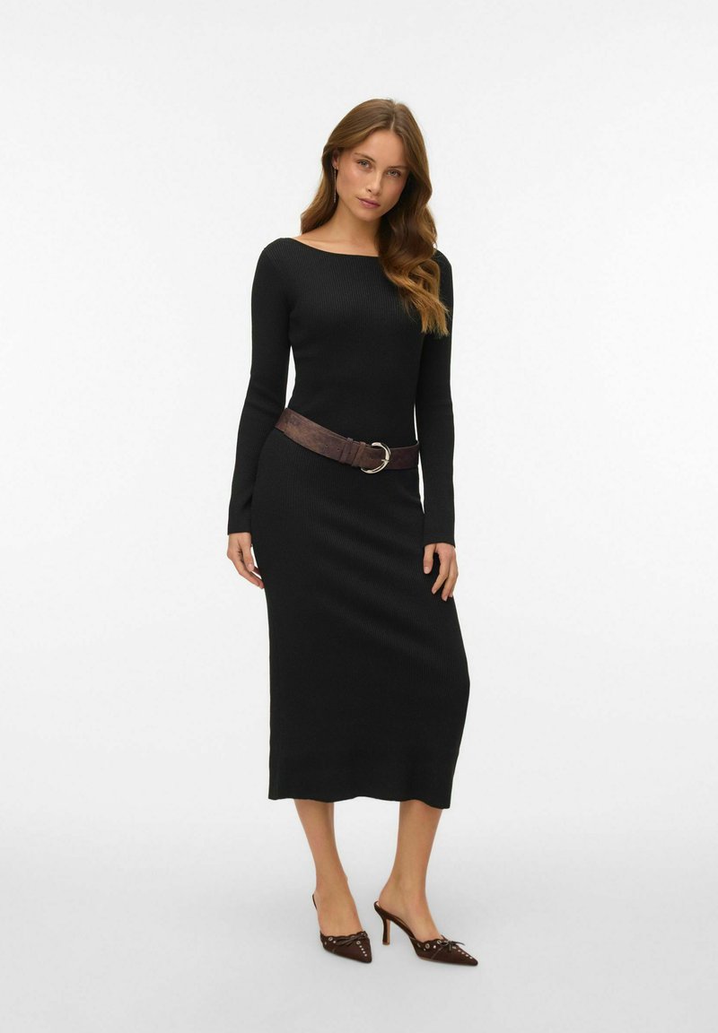 Melnas ribotas garām piedurknēm kleita ar kuģa kakla izgriezumu, sašūta jostasvietā ar brūnu jostu ar apaļu sprādzi, apvienota ar augstpapēžu kurpēm.