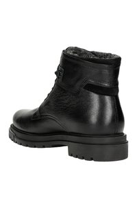 Stivaletto in pelle nera con superficie testurizzata, dettagli in suede, collare imbottito e suola in gomma nera robusta con scanalature.