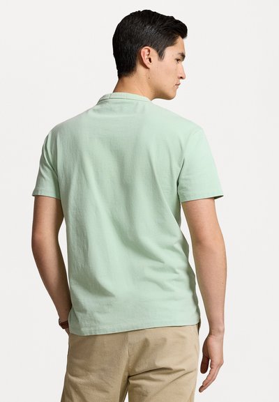 Mintgrön kortärmad t-shirt i bomull med avslappnad passform och rundad halsringning, med en slät yta och utan synliga mönster.