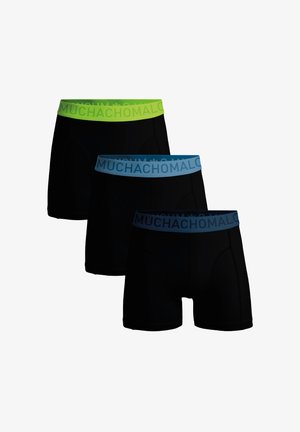 Schwarze Boxershorts mit kontrastierenden elastischen Bündchen in Grün und Blau, mit dem Schriftzug „MUCHACHOMALO“ in fetter Schrift.