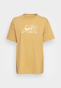 Gul bomullströja med rundad halsringning, korta ärmar och en vit "AIR"-logotyp över framsidan. Mjuk textur med en avslappnad passform.