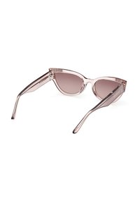 Gafas de sol estilo ojo de gato con montura de plástico rosa claro, lentes gradientes grises y patillas anguladas con la marca "GUESS" en dorado en el lateral.