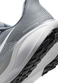 Chaussure de sport grise avec tige en mesh respirant, semelle blanche coussinée et semelle extérieure en caoutchouc noir texturé pour l’adhérence, vue de l’arrière.