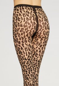 Gennemsigtige leggings med et leopardprint i sorte og brune nuancer, der har høj talje og en glat tekstur.