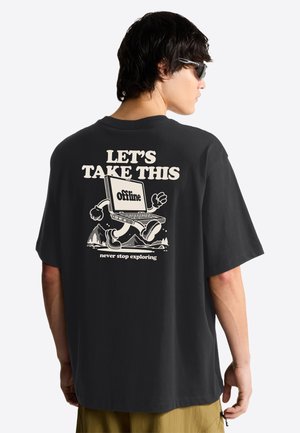 Person iført sort t-shirt med bærbar computer tegneserie, der går og teksten "LAD OS TAGE DET HER offline, stop aldrig med at udforske" på ryggen.