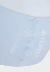 Světlomodrý sportovní čelenka vyrobená z elastického materiálu, s viditelným prošíváním a tištěným logem "TERREX". Hladký povrch a zakřivený tvar.