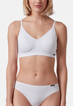 Bralette inalámbrico blanco con tirantes finos y textura suave, que cuenta con una banda ancha y una etiqueta de logo sutil en el lateral.