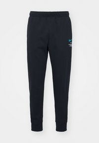 Svarta Nike-mjukisbyxor med resårmidja, avsmalnande ben, mjuk textur och turkos logotryck på den övre vänstra sidan.