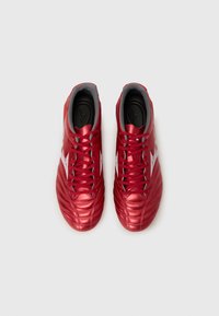 Rode voetbalschoenen met een gladde, glanzende textuur, gestroomlijnd ontwerp, voorzien van een vetersluiting aan de voorkant en een grijze binnenvoering.