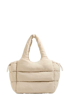 Sac fourre-tout beige rembourré avec un haut arrondi et deux poignées courbes, featuring des panneaux horizontaux cousus et une fermeture à cordon d'un côté.