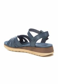 Sandalia de cuero azul marino con tiras entrelazadas, plantilla acolchada y suela de cuña texturizada en marrón claro. Incluye correa ajustable para el tobillo.