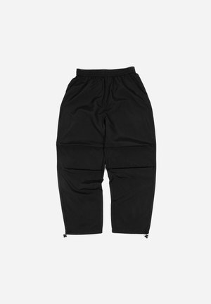 Schwarze leichte Hose mit elastischem Bund, schmaler Passform und Reißverschluss an den Bündchen. Hergestellt aus einem glatten, wasserabweisenden Material.