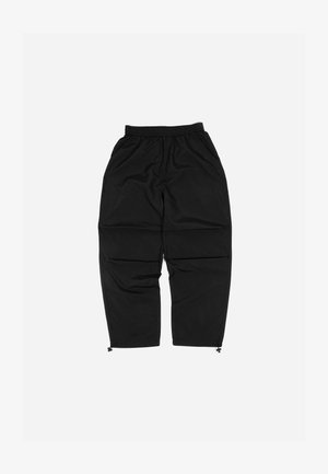 Črne lahke hlače z elastičnim pasom, zožanimi hlačnicami in zadrgo na robovih. Narejene so iz gladkega, vodoodpornega materiala.