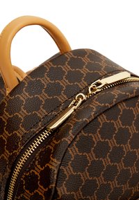 Zaino in pelle marrone con motivo, dotato di hardware in tonalità oro, chiusura con zip e manico in pelle beige sulla parte superiore.