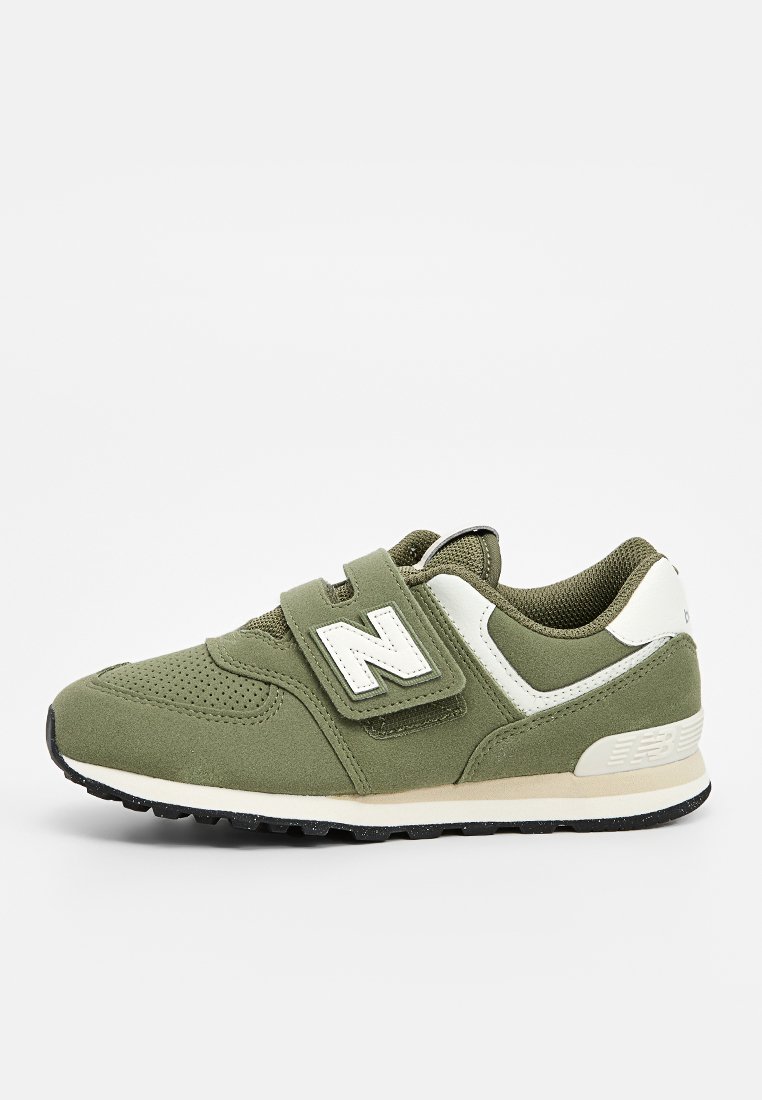 Chaussure de sport verte avec une tige en mesh respirant, une sangle Velcro, des accents blancs et une semelle en caoutchouc texturée. Design classique avec un détail de logo.