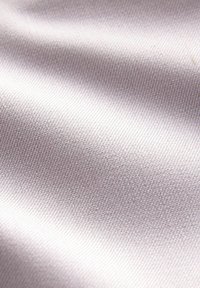Tissu gris clair avec une texture lisse, présentant un motif tissé subtil. La surface semble légèrement réfléchissante sous la lumière.