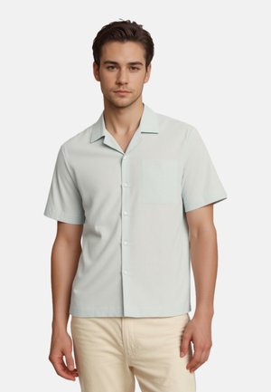Lichtblauw overhemd met korte mouwen, gemaakt van zachte stof, met een knoopsluiting aan de voorkant en een borstzakje aan de linkerzijde.