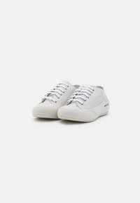 Sneaker bianche in suede con una finitura liscia, dotate di punte arrotondate, lacci bianchi e logo discreto di lato.