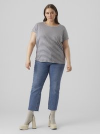 Ριγέ κοντομάνικη μπλούζα σε γκρι και ναυτικό μπλε, συνδυασμένη με μπλε τζιν παντελόνι με ξεχειλωμένο τελείωμα, και μπεζ πλατφόρμες με υφασμάτινες κάλτσες.