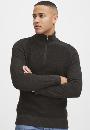 Dunkelgrauer Strickpullover mit Reißverschluss, langen Ärmeln, strukturiertem Stoff, Stehkragen und einem kleinen Logopatch an der unteren linken Seite.