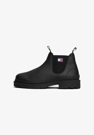 Melni ādas potītes Chelsea zābaki ar teksturētu virsmu, elastīgām sānu paneļiem un cilpu. Aprīkoti ar masīvu gumijas zoli un logo detalizāciju.