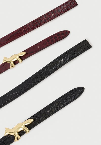 Δύο δερμάτινες ζώνες με υφή κροκοδείλου, μία μπορντό και μία μαύρη, η καθεμία διαθέτει μια χρυσή αγκράφα σε σχήμα αλεπούς σε λευκό φόντο.