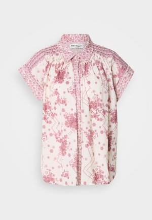 Lühikeste varrukatega blouse, mis on valmistatud heledast kreemjast kangast, millel on roosad lillemustrid ja dekoratiivne smokk kaeluses ja õlgadel.