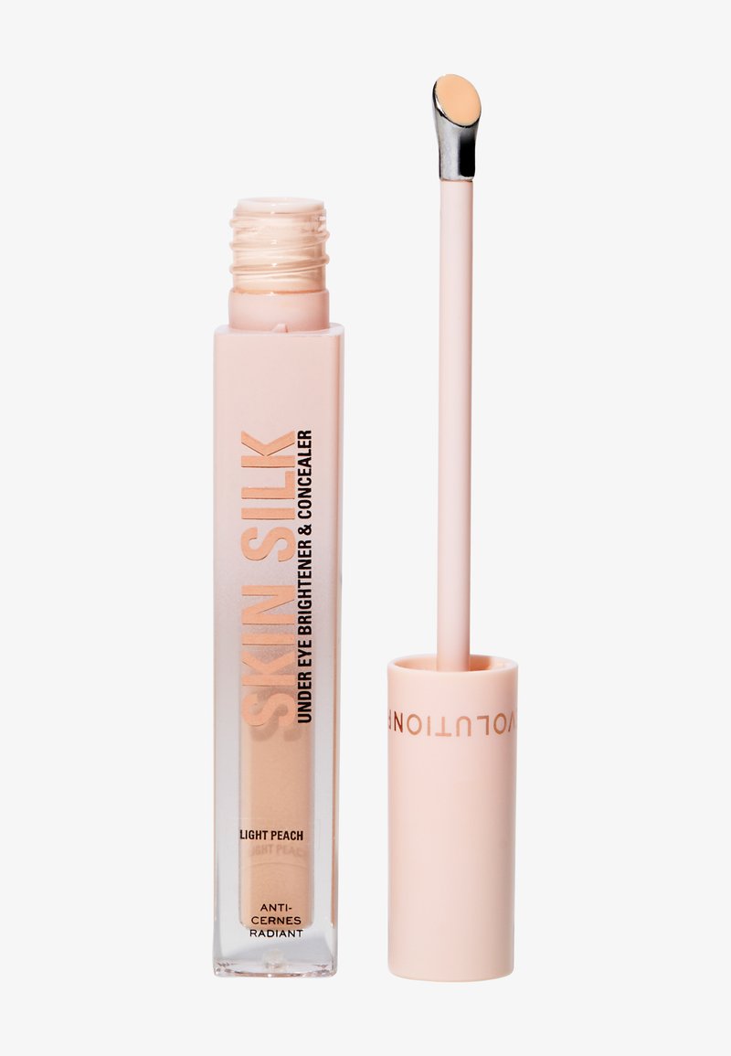 Ljus persikofärgad ljusreflekterande concealer under ögonen i en transparent tub med ett rosa lock; har en liten applikator med en slät spets.