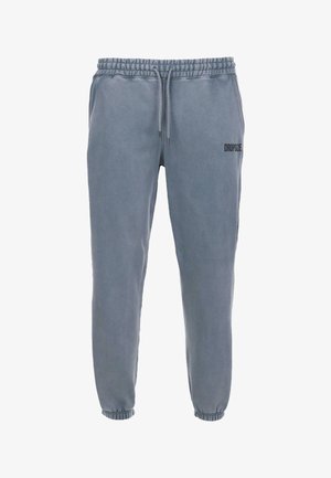 Harmaat puuvillapöksyt, joissa on elastinen vyötärö, nyöri ja kuminauhakäytännöt nilkoissa. Vasemmassa reidessä on "DROPSIZE"-logo.