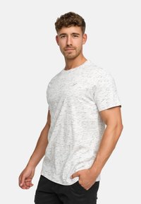 T-shirt gris clair à manches courtes avec un motif moucheté, col rond, texture douce et logo subtil sur la poitrine.