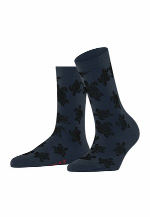 Marinefarbene Socken mit einem Schildkrötenmuster in Schwarz. Gerippte Bündchen, mittellang, aus Baumwollmischung. Rote Textakzente auf der Unterseite.