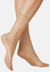 Nackte, transparente Strumpfhosen mit glatter Textur und semi-transparenter Optik, die eine abgerundete Zehenpartie und einen bequemen Sitz am Bein zeigen.