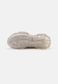 Durchsichtige Sport-Schuhsohle mit strukturiertem Oberflächen und Zick-Zack-Muster für besseren Halt. Sichtbare Dämpfungselemente an der Ferse und im Vorfußbereich.